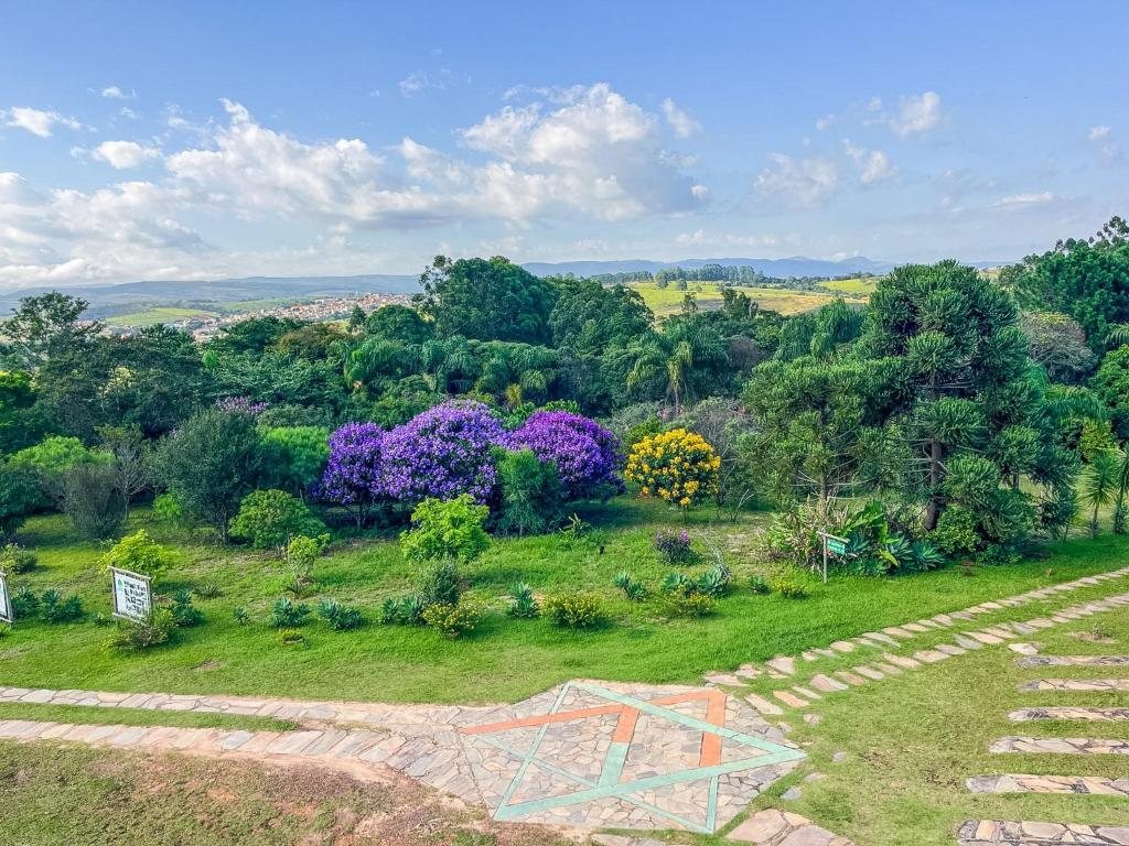 Jardim com ipês floridos e vista do vale
