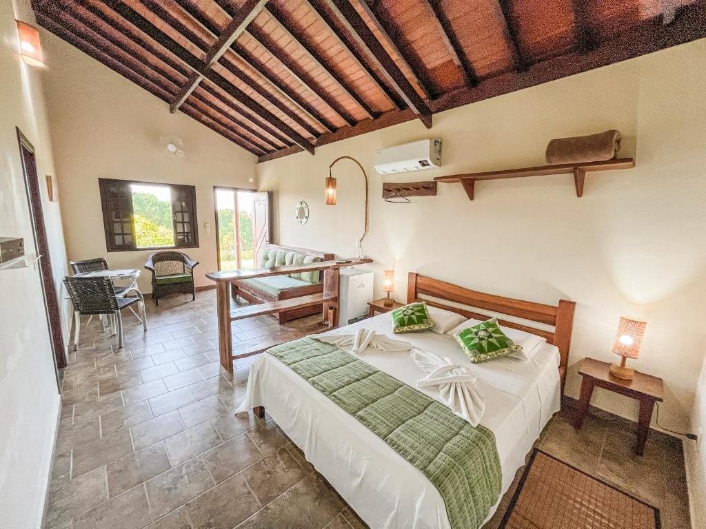 Suíte com teto de madeira, cama queen e varanda